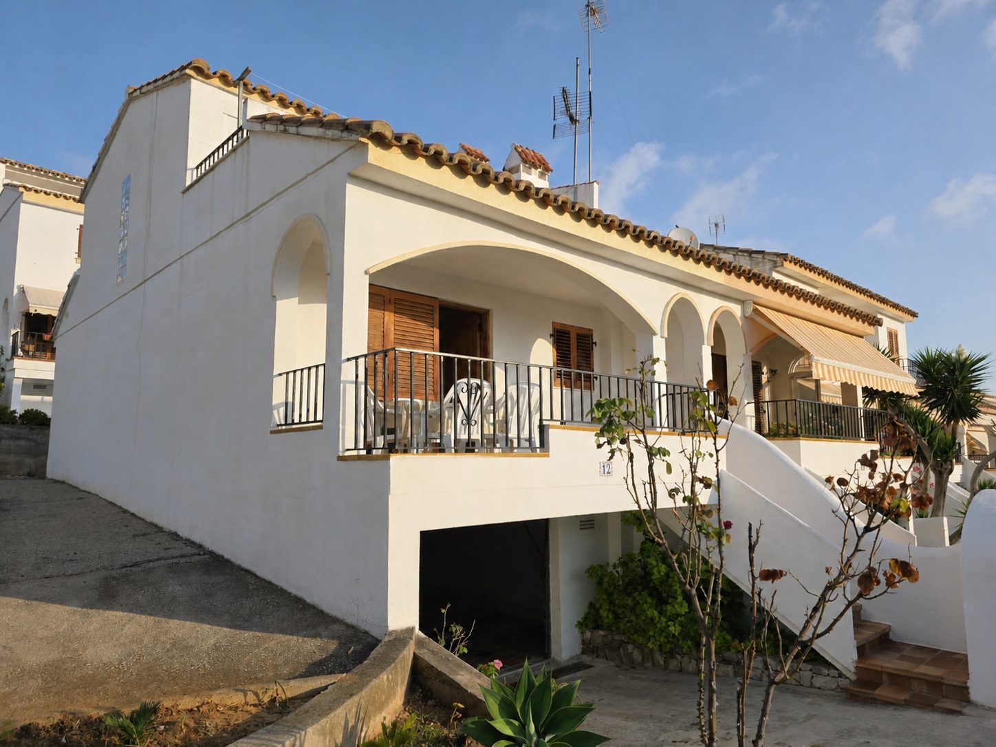 Fachada del chalet con la terraza y el garaje